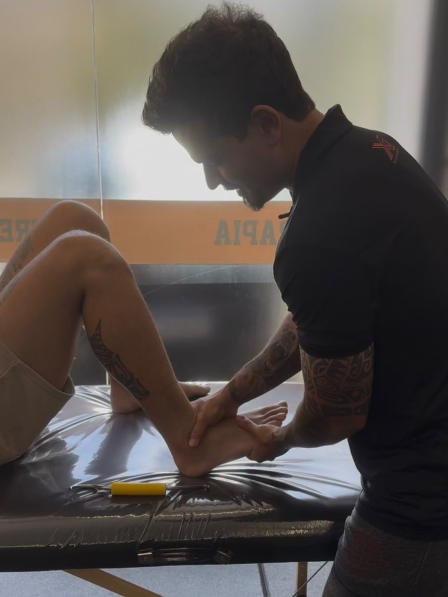 Bernardo Jacques tratando o tornozelo de um paciente em sessão de fisioterapia esportiva